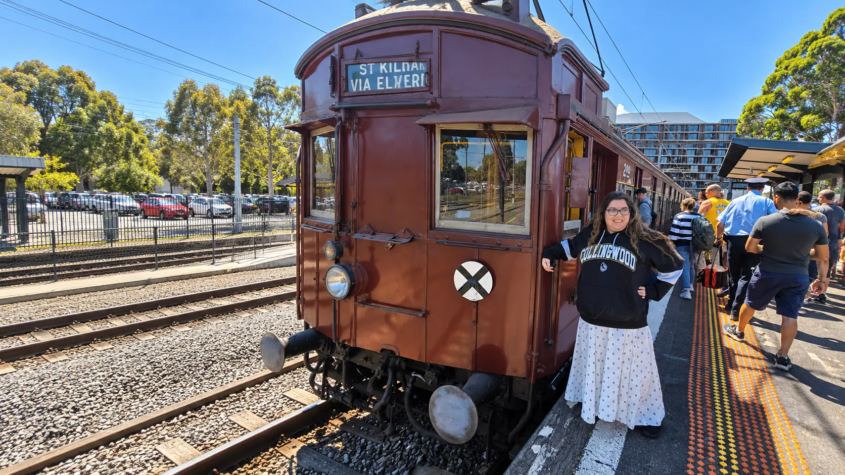 A woman enjoying an outing beside a heritage tram