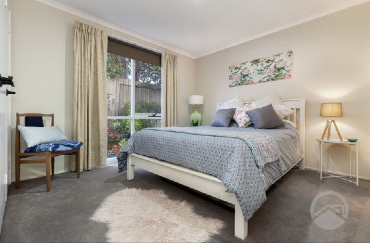 A bright bedroom at Cranbourne North House with garden views