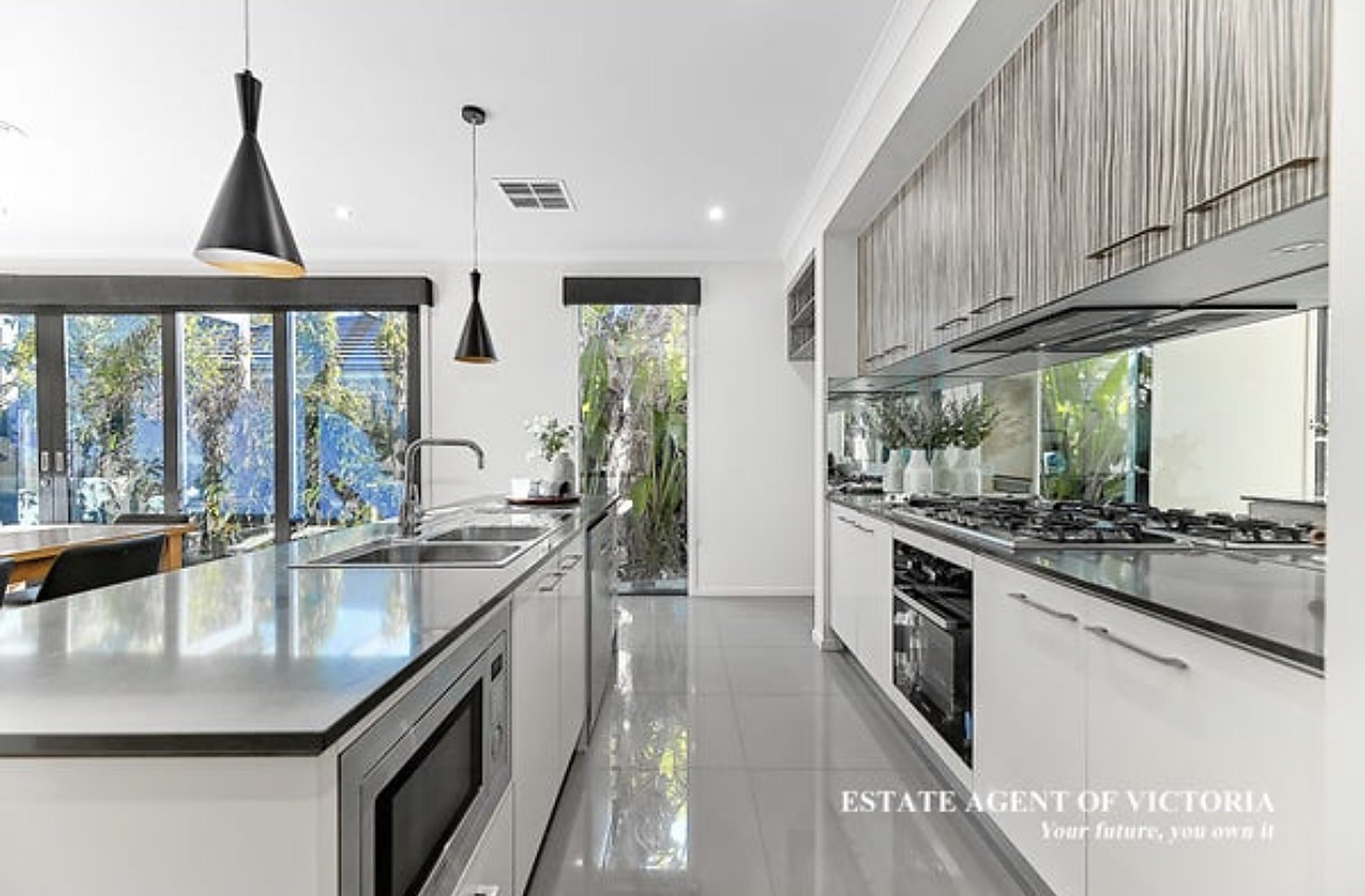 The open-plan kitchen at Clyde North House with stone benchtops