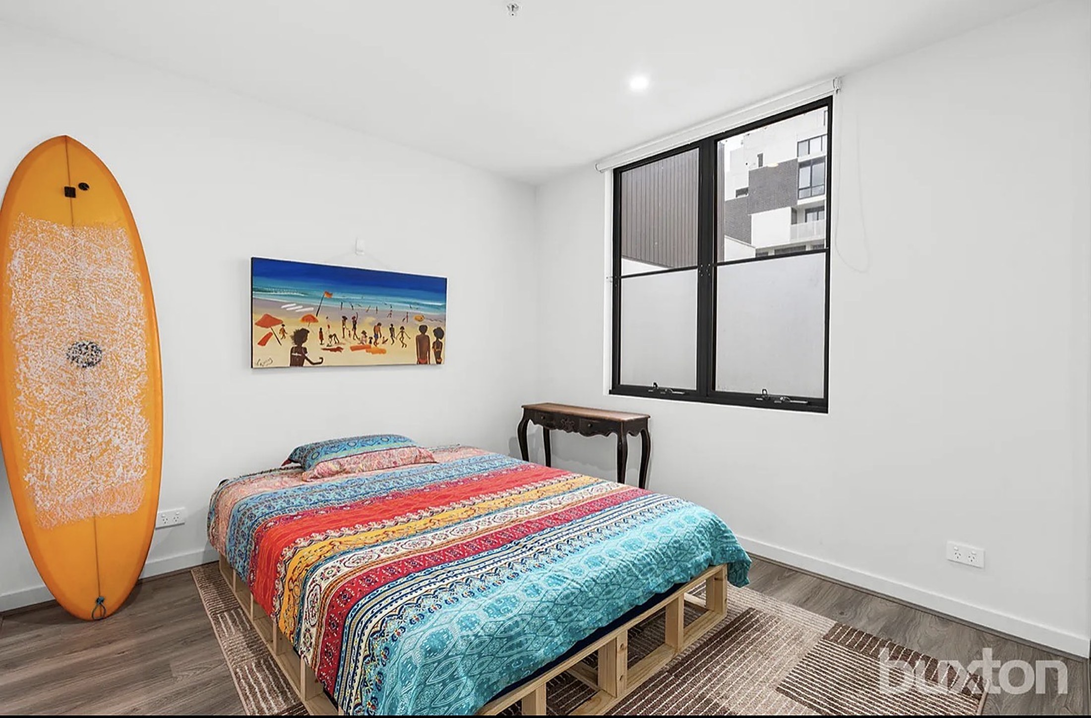 A bright bedroom at Mentone House with a beach artwork