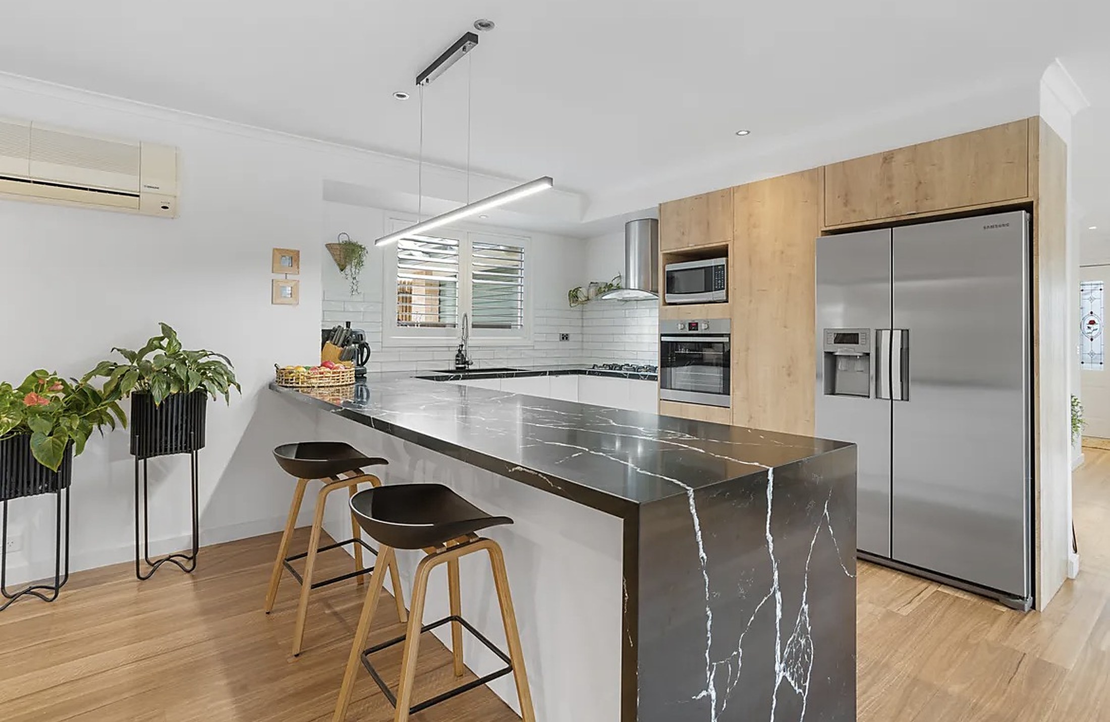 The bright kitchen with a stone island bench at Mornington House