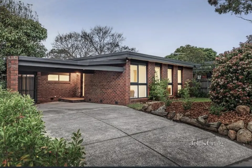The front of Viewbank House at dusk, with its brick facade and landscaped garden