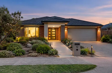 A modern single-storey home with a landscaped garden at dusk
