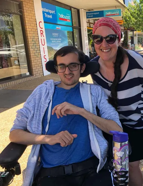 A man using a wheelchair and a woman smiling together on a community outing