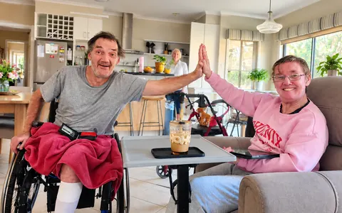 Two people sharing a high five in a bright open-plan home living room