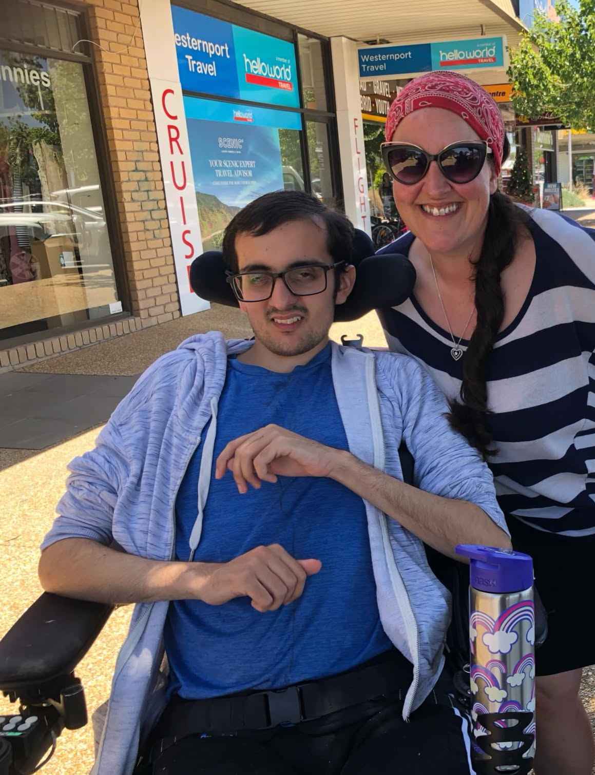 A man using a wheelchair and a woman smiling together on a community outing