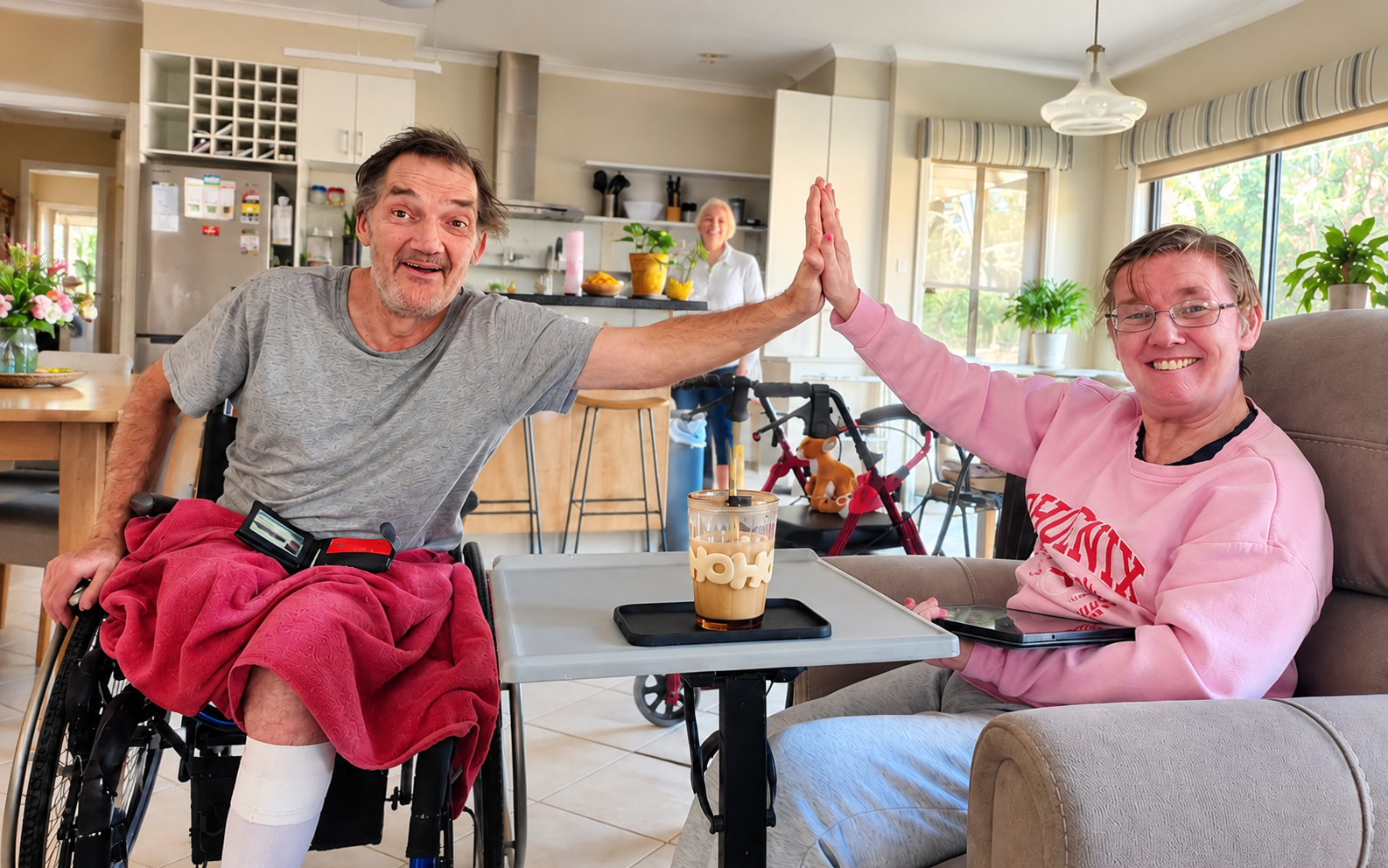 Two people sharing a high five across a tray table at home