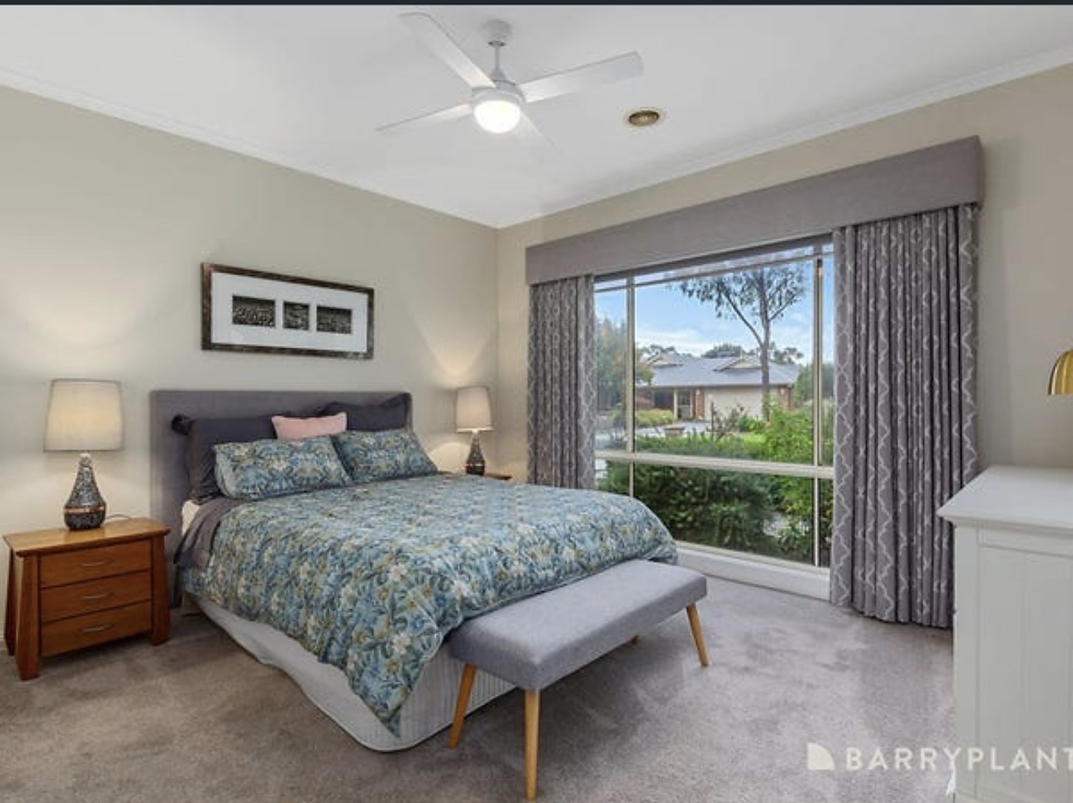 A bright bedroom at Sunset House with garden views through the window